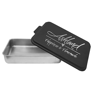 May include: Black rectangular cake pan with a silver lid. The lid has the text "Ashland Happiness is Homemade" with a small heart symbol.