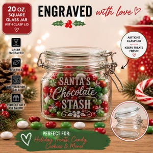 May include: A 20 oz. square glass jar with an airtight metal clasp lid. The jar is laser engraved with the text "SANTA'S Chocolate STASH" surrounded by snowflake designs. It is filled with red, green, and white chocolate candies.