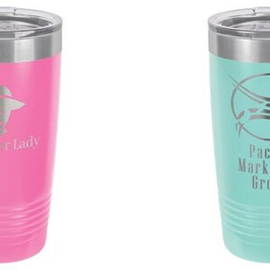 May include: Two insulated tumblers. One is pink with the text "Glamor Lady" and a logo. The other is teal with the text "Pacific Marketing Group" and a logo. Both have a silver rim and lid.