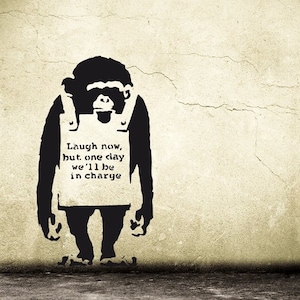 Könnte beinhalten: Schwarz-weiß-Schablone eines Affen, der eine Weste mit dem Text "Laugh now, but one day we'll be in charge" auf einer beigefarbenen Wand trägt.
