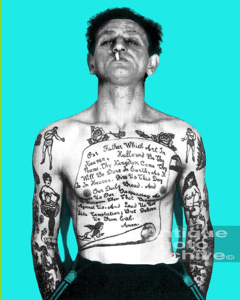 May include: A black and white photo of a man with a full-body tattoo of the Lord's Prayer. The tattoo is on his chest and arms. The man is looking at the camera and has a cigarette in his mouth.