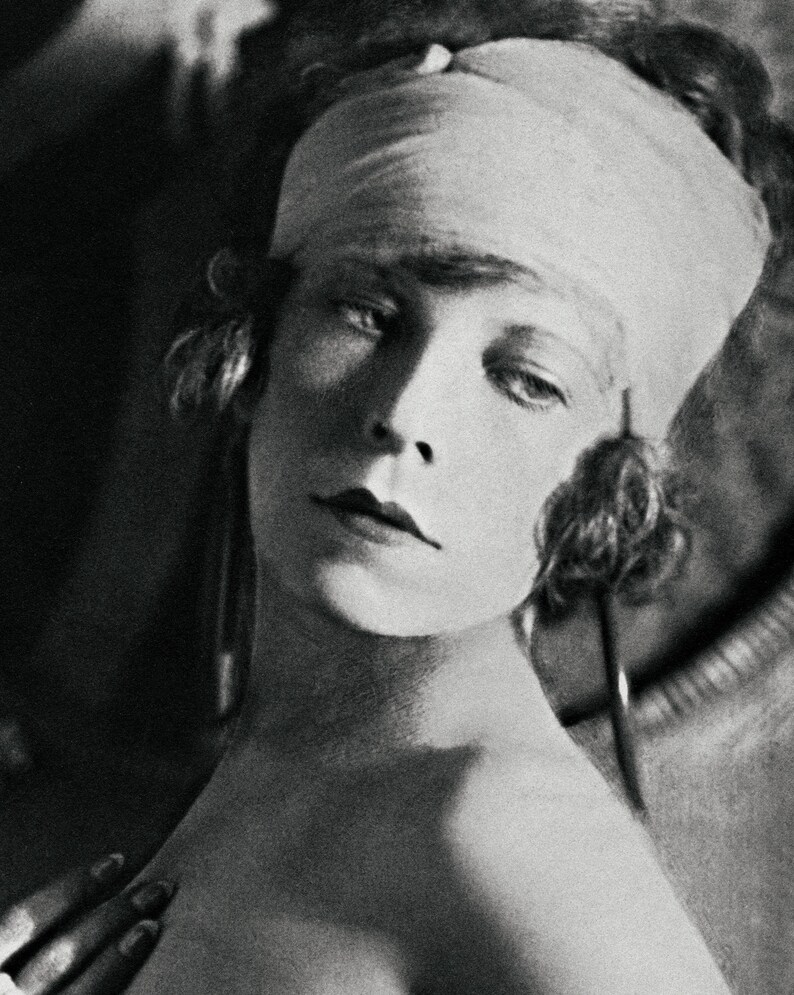 May include: A black and white portrait of a woman with a bandage on her head. The woman is looking to the side and has a serious expression on her face.