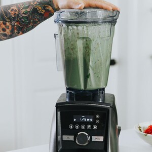 Puede incluir: Una licuadora negra y plateada con un batido verde en su interior. La licuadora tiene una pantalla digital que muestra "7/ 0:10".