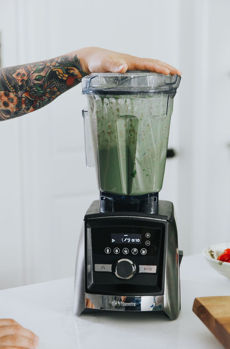 Puede incluir: Una licuadora negra y plateada con un batido verde en su interior. La licuadora tiene una pantalla digital que muestra "7/ 0:10".