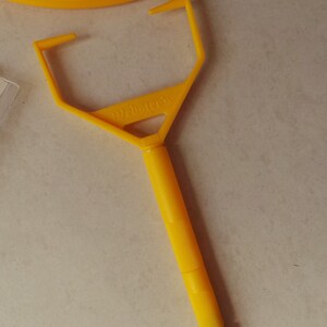 May include: A yellow plastic tool with a handle and a pointed end. The tool is labeled "Weldbetter's".