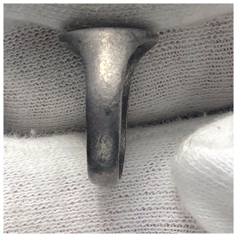 Pu&ograve; includere: Un anello d'argento con una fascia liscia e una parte superiore arrotondata e liscia.