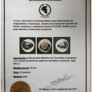 Pu&ograve; includere: Un certificato di autenticit&agrave; per un anello d'argento in stile bizantino. L'anello presenta una croce latina e l'iscrizione "VN" con cerchi concentrici. L'anello ha un diametro di 16 mm e pesa 2,9 grammi. Il certificato &egrave; datato 28 settembre 2017.