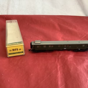 May include: A green and gray model train car with the text "51 3172 00 MINITRIX" on the box.