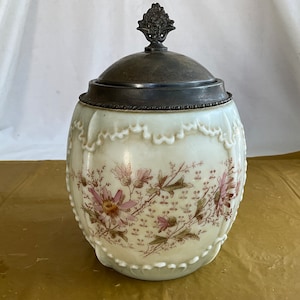 9”T Wave Crest Cream-Colored Basket Jar With Metal Rim and Lid and Hand Painted Pink Daisy Design
