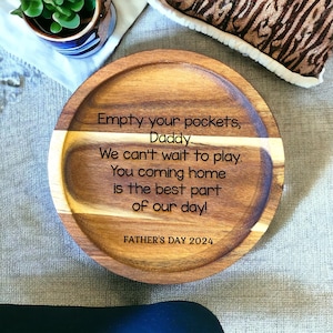 Puede incluir: Una bandeja de madera con el texto "Empty your pockets, Daddy. We can't wait to play. You coming home is the best part of our day!" y "FATHER'S DAY 2024" grabado en ella.
