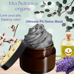 May include: A glass jar with a black charcoal detox mask for underarms. The jar has a brown lid and is labeled "Ultimate Pit Detox Mask". The image also includes a small bottle of oil and a sprig of lavender.