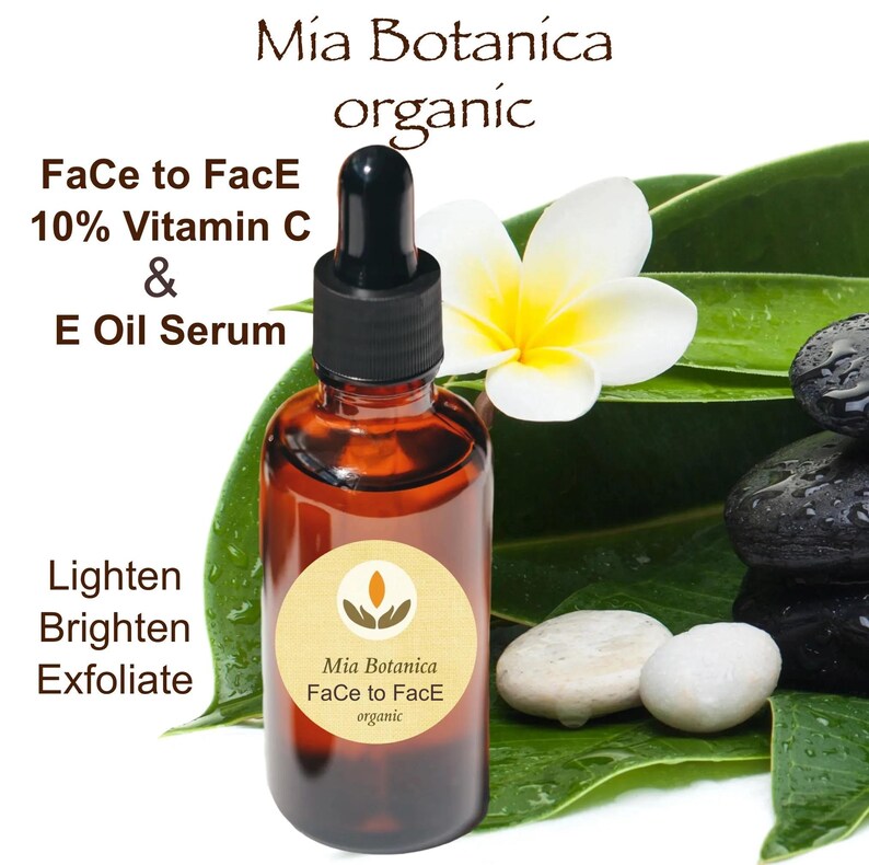 May include: A brown glass bottle with a dropper top, labeled "Mia Botanica Face to Face organic" and "10% Vitamin C & E Oil Serum". The bottle is sitting on a green leaf with white stones and a white flower.