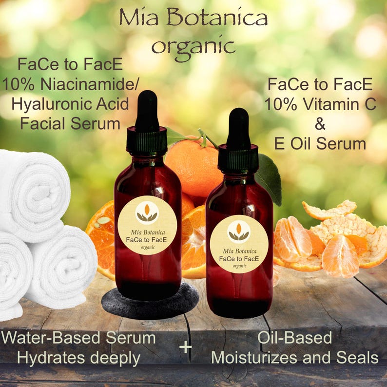 May include: Two amber glass bottles with dropper tops, labeled "Mia Botanica Face to Face organic" and containing facial serums. The bottles are on a wooden surface with orange slices and peels. The text "Face to Face 10% Niacinamide/Hyaluronic Acid Facial Serum" and "Face to Face 10% Vitamin C & E Oil Serum" is visible. The text "Water-Based Serum Hydrates deeply" and "Oil-Based Moisturizes and Seals" is also visible.