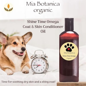 May include: A brown bottle of Mia Botanica Shine Time Omega Coat & Skin Conditioner Oil. A smiling corgi dog and a silver alarm clock are next to the bottle. The text reads, "Time for soothing dry skin and a shiny coat!"