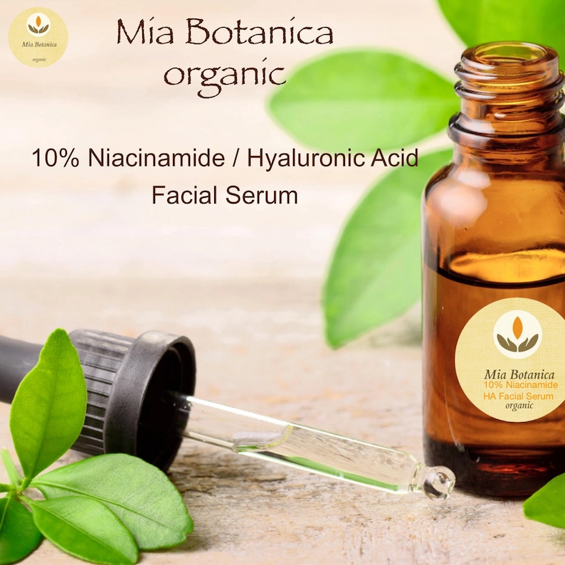 May include: A brown glass bottle with a dropper, labelled "Mia Botanica 10% Niacinamide HA Facial Serum organic". The bottle is sitting on a wooden surface with green leaves.