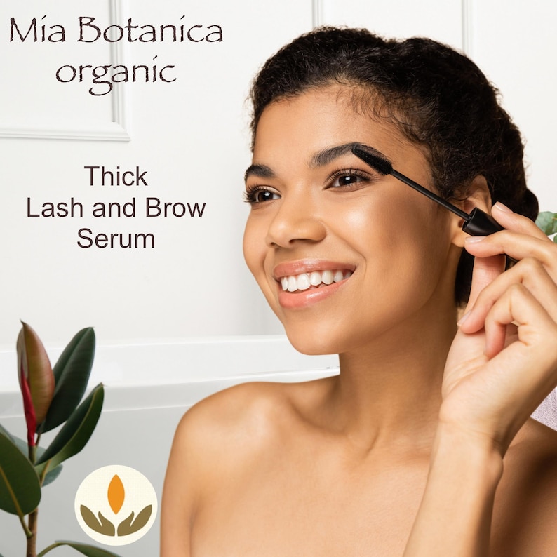 K&ouml;nnte beinhalten: Eine Frau tr&auml;gt einen schwarzen Mascara-Applikator auf ihre Augenbraue auf. Der Text auf dem Bild lautet "M&iacute;a Bot&aacute;nica organic Thick Lash and Brow Serum".