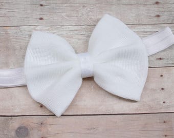 May include: A white fabric bow headband with a white elastic band.