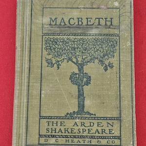 May include: A hardcover book titled Macbeth from The Arden Shakespeare series, published by D. C. Heath & Co. The olive green cloth cover features a dark green illustration of a tree and black text centered within a rectangular border design.