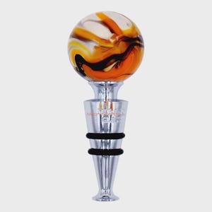 May include: A decorative bottle stopper with a marbled glass orb in shades of orange, white, and black. The stopper has a polished silver base with the text "Murano Glass". Two black rubber rings provide a tight seal.