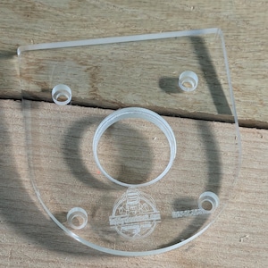 May include: A clear plastic template with a circular cutout and four smaller holes. The template is engraved with the text "Midland Tool & Supply Co. Inc.  Made in USA".