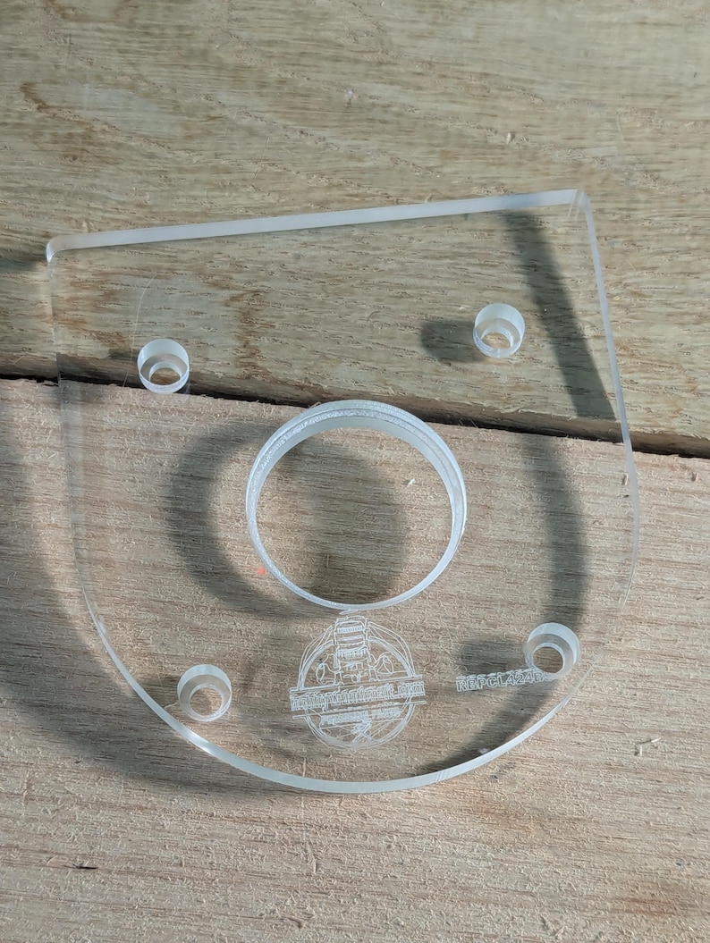 May include: A clear plastic template with a circular cutout and four smaller holes. The template is engraved with the text "Midland Tool & Supply Co. Inc.  Made in USA".