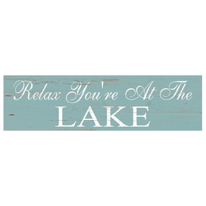 May include: A light blue wooden sign with white text that reads "Relax You're At The LAKE".