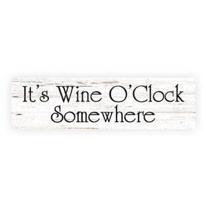 May include: White wooden sign with black text that reads "It's Wine O'Clock Somewhere".