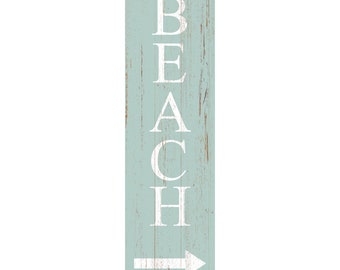 May include: A vertical rectangular sign with a light blue, distressed wood-grain finish. The word BEACH is printed in large, white, capital letters stacked vertically, followed by a white arrow pointing to the right at the bottom.
