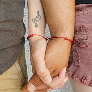Matching magnetic cord bracelets worn by couple