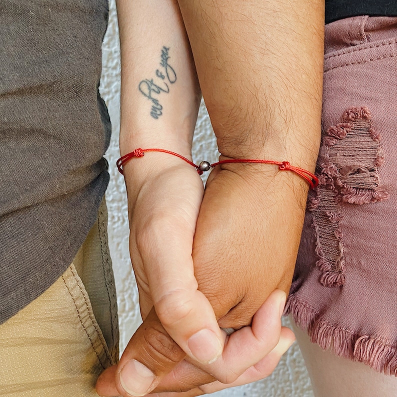 Matching magnetic cord bracelets worn by couple