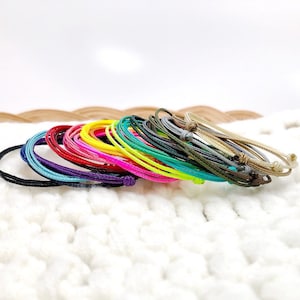 Colorful stackable string bracelets available in assorted waterproof cord colors