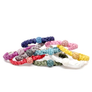 May include: A set of eight braided bracelets with lava rock beads in various colors, including pink, blue, green, red, yellow, white, gray, and navy.