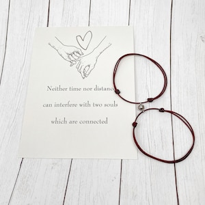 Magnetic matching couple bracelets with printed gift card displayed flat lay