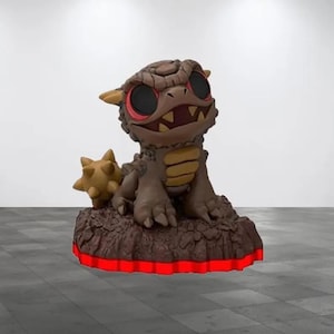 May include: A brown and tan figurine of a dragon-like creature with large eyes and a spiky tail. The figurine sits on a brown base with a red glowing border. The creature has a menacing expression.