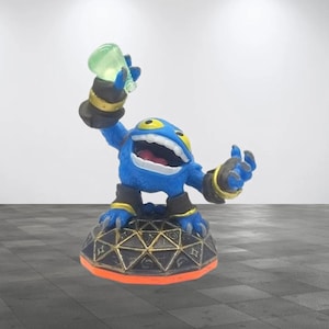 May include: Blue and yellow Skylanders figure holding a green potion. The figure is standing on a black and gold base.