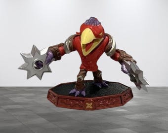 May include: A red and yellow bird-like action figure with purple accents, wearing armor and holding silver star-shaped weapons. The figure stands on a decorative base with a red and brown color scheme.