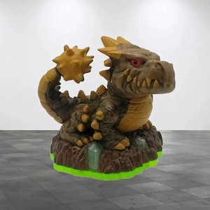 May include: A brown and yellow dragon figurine with a spiky tail and red eyes. The dragon is standing on a brown base with green crystals.