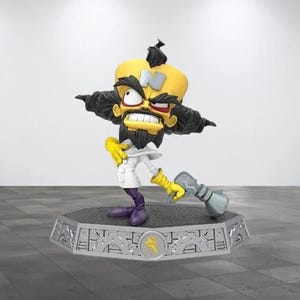May include: A stylized figurine of a character with a large yellow head, a prominent silver letter N on the forehead, wild black hair, and a black beard. The figure wears a white lab coat, yellow gloves, and purple boots, holding a silver ray gun.