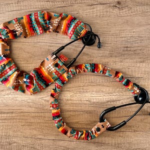 May include: Two stethoscope covers with a colorful southwestern pattern. The covers are made of fabric and have a stretchy fit.