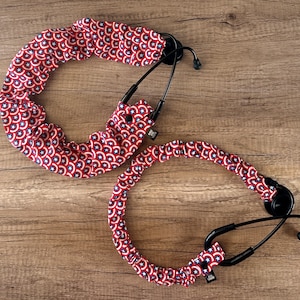 May include: Two stethoscope covers with a red, white, and blue star pattern. The covers are made of fabric and have a stretchy design.