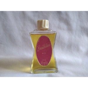 May include: A clear glass bottle of "Breathless Mist" perfume. The bottle has a white plastic cap and a red oval label with white lettering. The label reads "Breathless Mist" and "3 fl oz. Chambord Toiletries, Inc. New York."