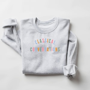 May include: A gray sweatshirt with the text "CLASSICAL CONVERSATIONS" printed in rainbow colors.