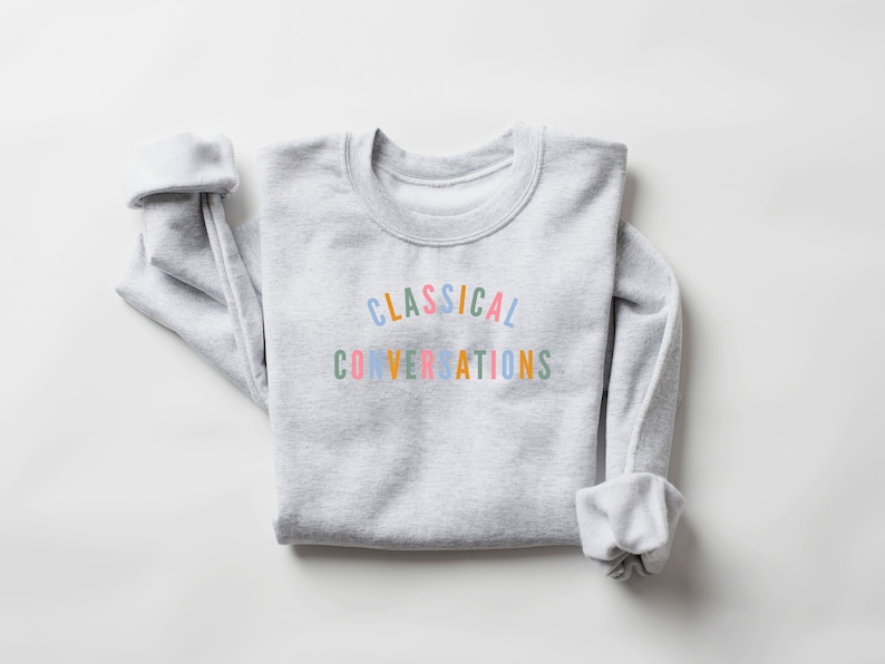 May include: A gray sweatshirt with the text "CLASSICAL CONVERSATIONS" printed in rainbow colors.