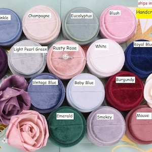 May include: Assortment of 15 round velvet ring boxes in various colors, including periwinkle, champagne, eucalyptus, blush, violet, light pearl green, rusty rose, white, royal blue, burgundy, vintage blue, baby blue, emerald, smokey, and mauve.