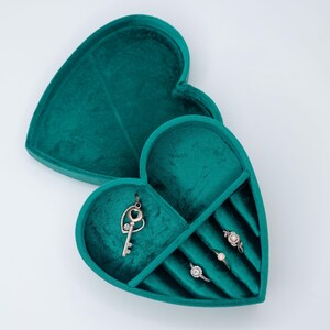 May include: A teal velvet heart-shaped jewelry box with compartments for rings and a key charm.