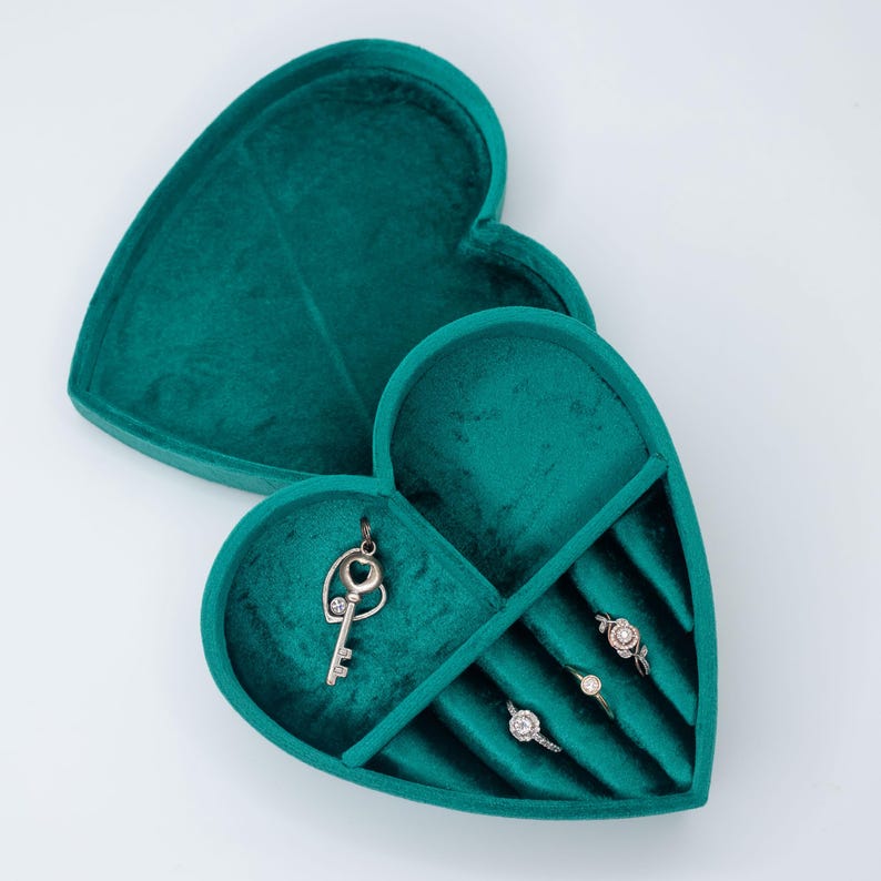 May include: A teal velvet heart-shaped jewelry box with compartments for rings and a key charm.