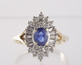 May include: A gold ring with a large blue sapphire surrounded by smaller diamonds.