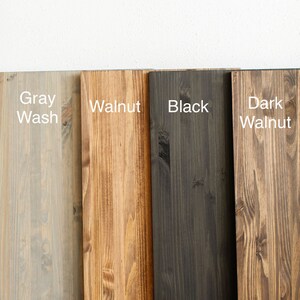 May include: Four wood samples stained in different colors: gray wash, walnut, black, and dark walnut.