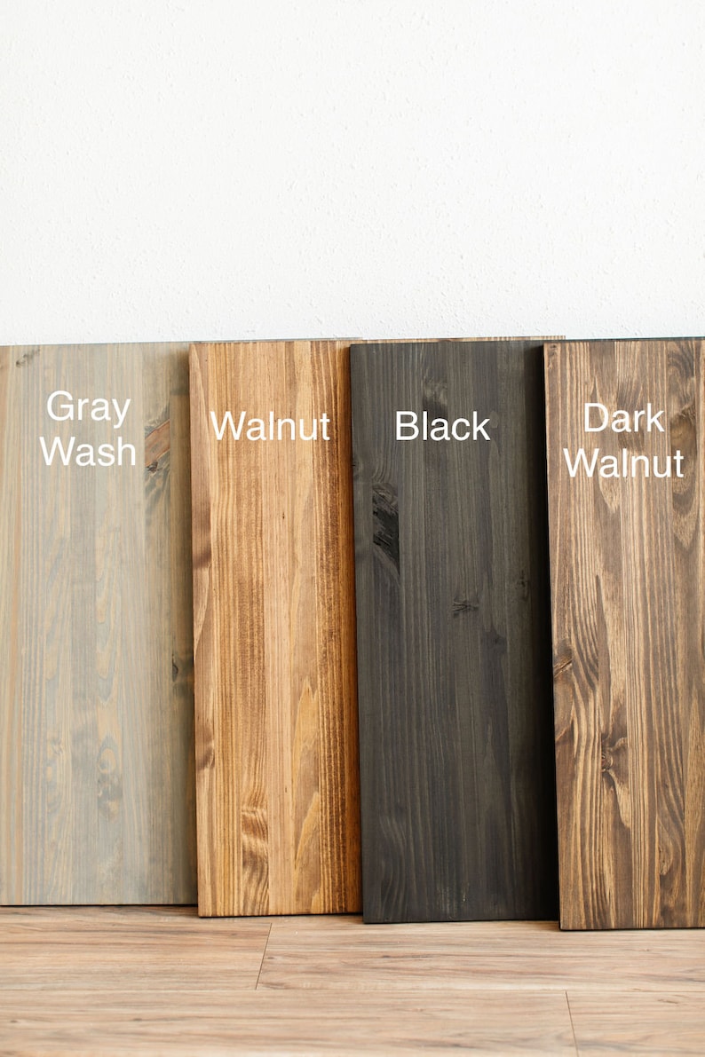 May include: Four wood samples stained in different colors: gray wash, walnut, black, and dark walnut.