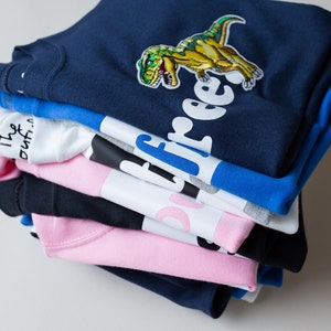 The Joyful Rebel collection of t-shirts - lots of colours, pale pink, navy blue, royal blue, black, white and grey.